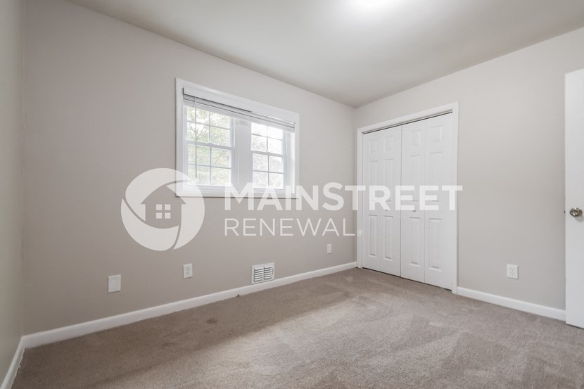 a bedroom with a carpeted floor and a white door