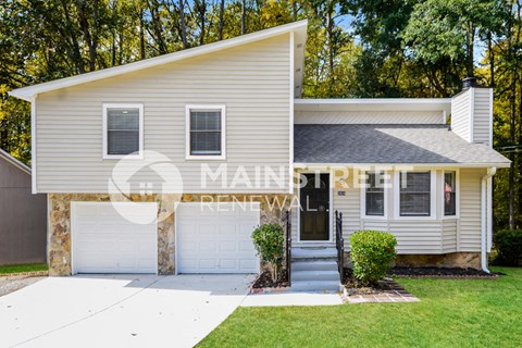 a white house with a white garage door and a lawn