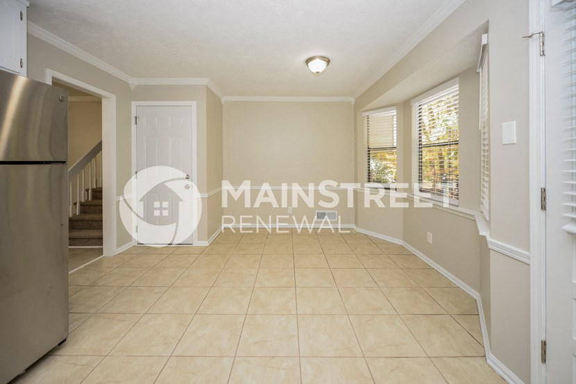 a large eat in kitchen with a door to a staircase