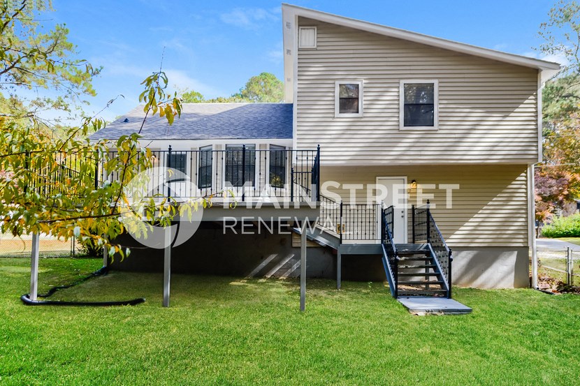 a house with a yard and a deck with a staircase