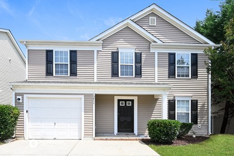 a white house with black shutters and a white garage door