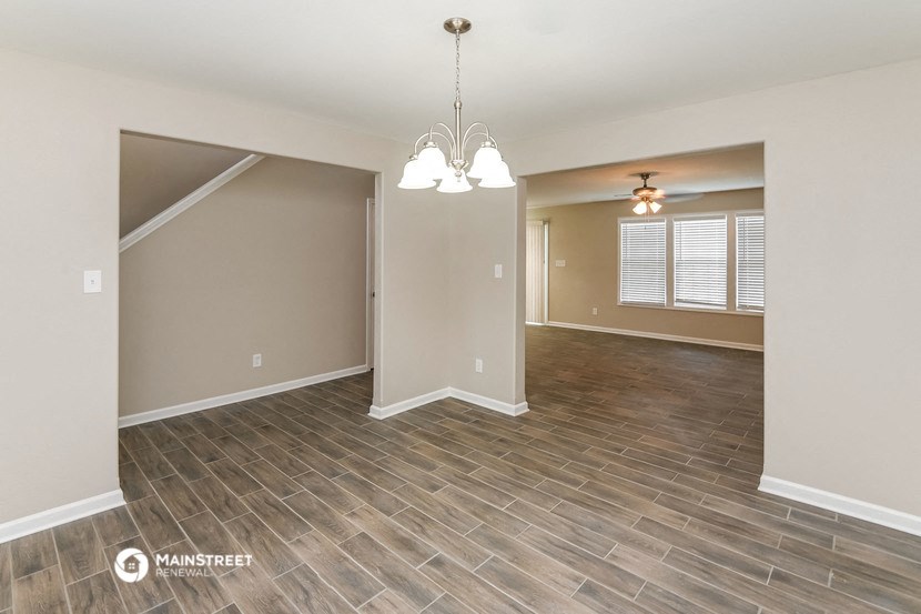 the spacious living room and dining room with wood flooring