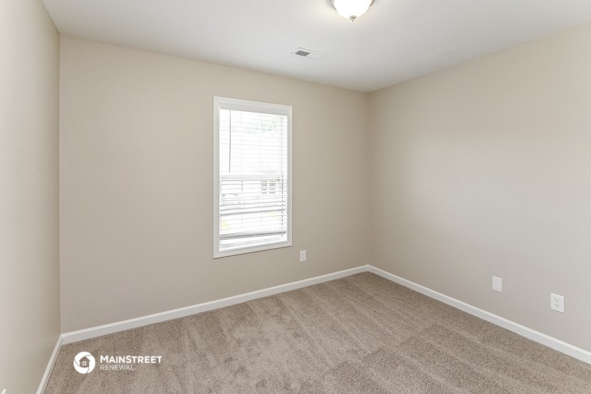 an empty room with carpet and a window