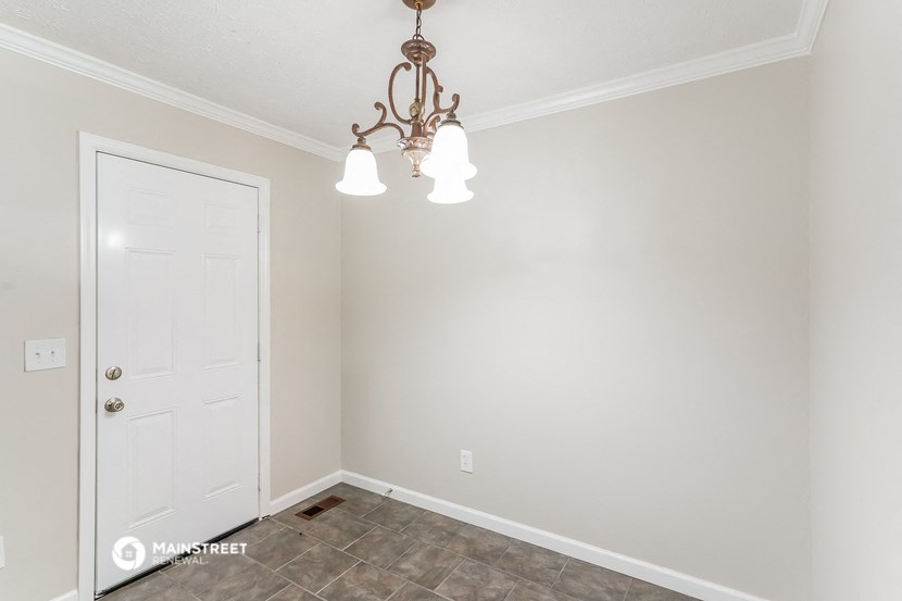 a bedroom with a white door and a chandelier