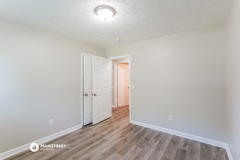 a living room with white walls and wood flooring