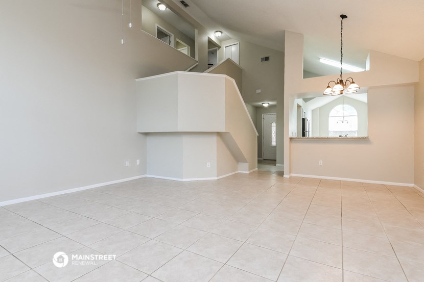 the spacious living room and dining room with the staircase to the second floor