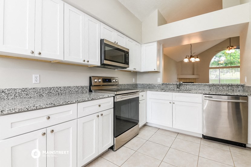 the kitchen has granite counter tops and stainless steel appliances