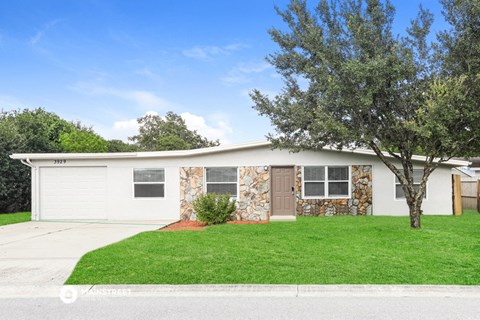 a small white house with a lawn in front of it