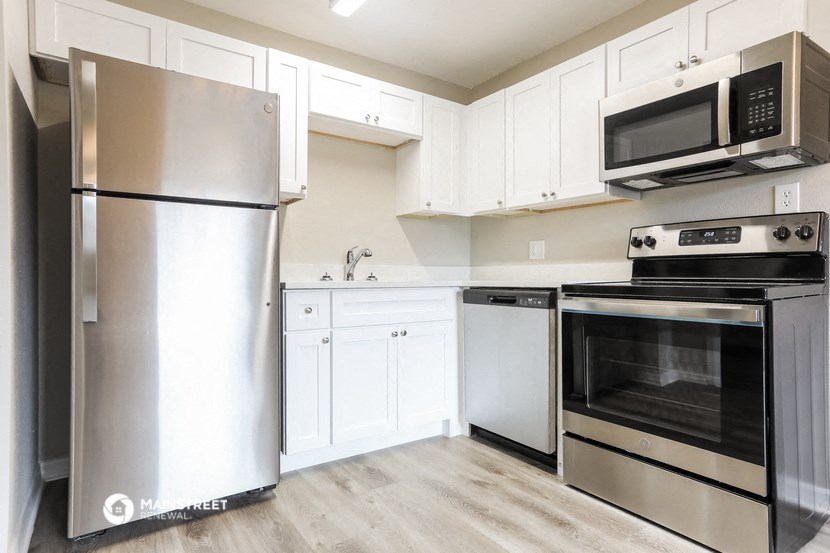 a kitchen with stainless steel appliances and white cabinets
