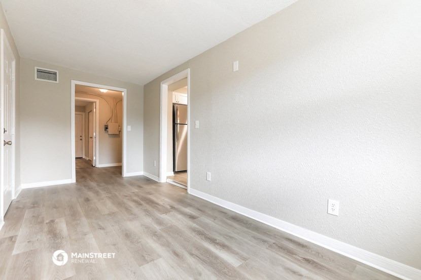 the living room and dining room of an apartment with wood flooring