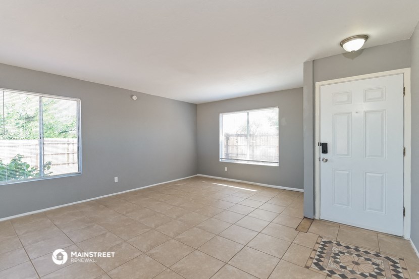 the living room of an empty house with a white door