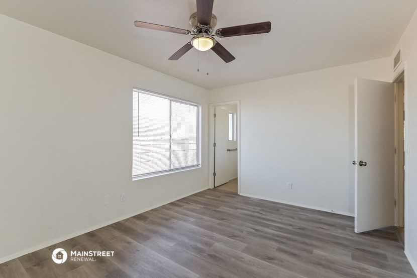 the living room of an empty house with a ceiling fan