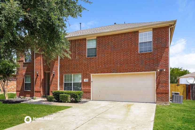 a red brick house with a white garage door