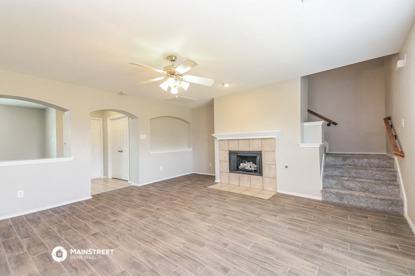 a living room with a fireplace and a ceiling fan