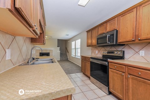 a kitchen with wooden cabinets and black appliances