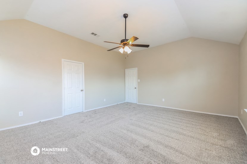 an empty living room with a ceiling fan
