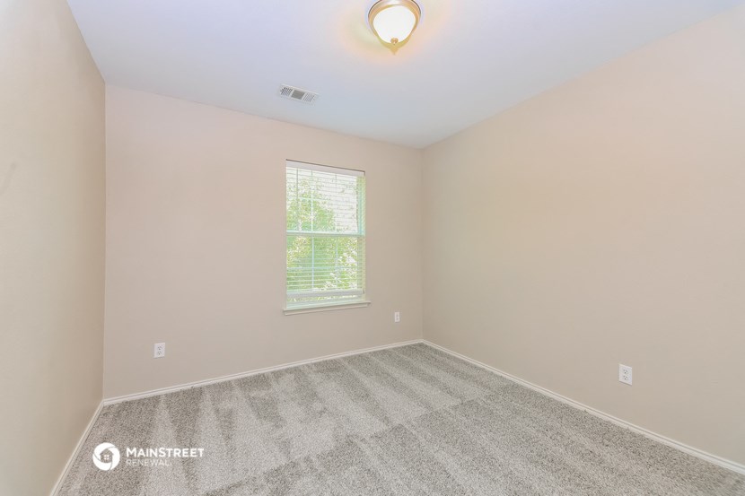 an empty room with carpet and a window