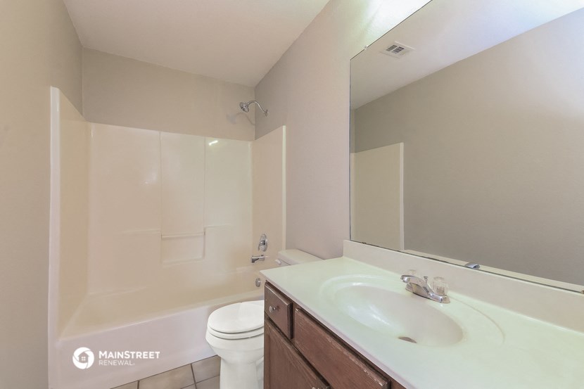 a bathroom with a sink toilet and a mirror