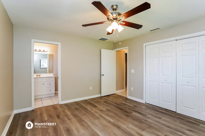 the master bedroom has a large closet and a ceiling fan