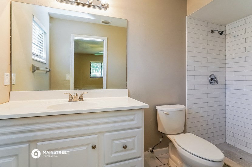 a bathroom with a sink toilet and a mirror