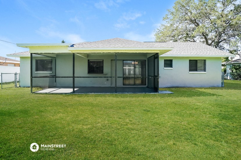 a white house with a screened in porch and a lawn