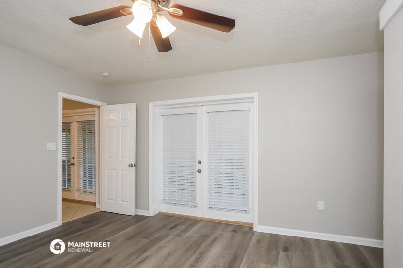 a living room with a ceiling fan and a door to a closet