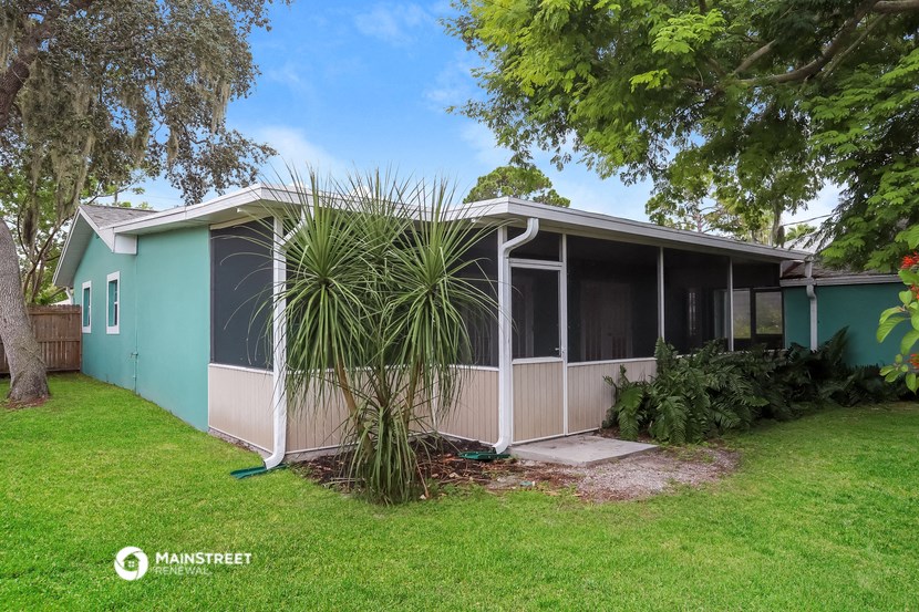 a light blue house with a palm tree in front of it