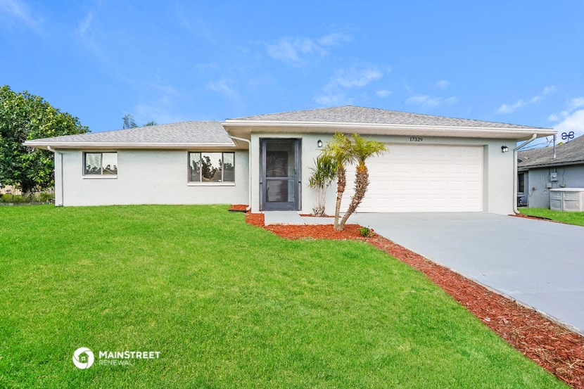 a white house with a palm tree in the front yard