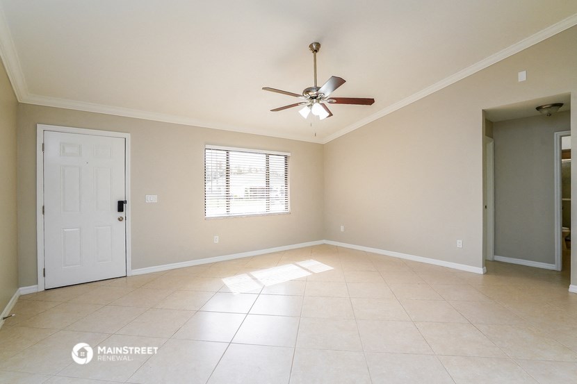 an empty living room with a ceiling fan