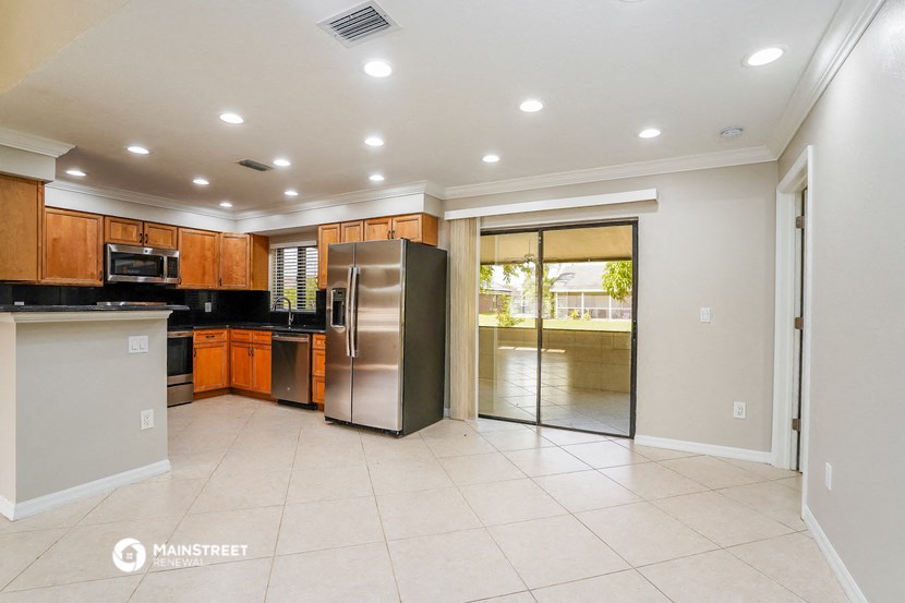 a large kitchen with stainless steel appliances and a door to the yard