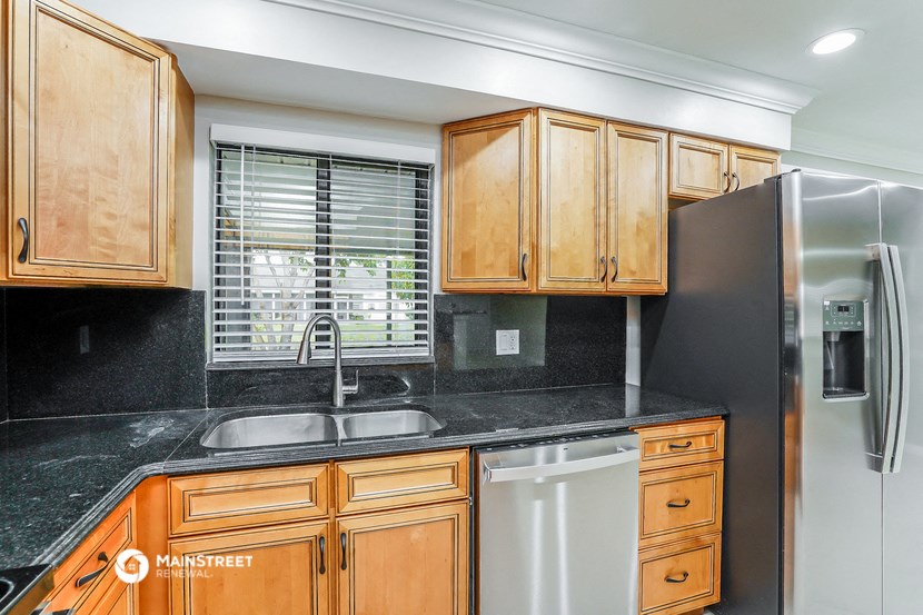 a kitchen with wooden cabinets and a stainless steel refrigerator