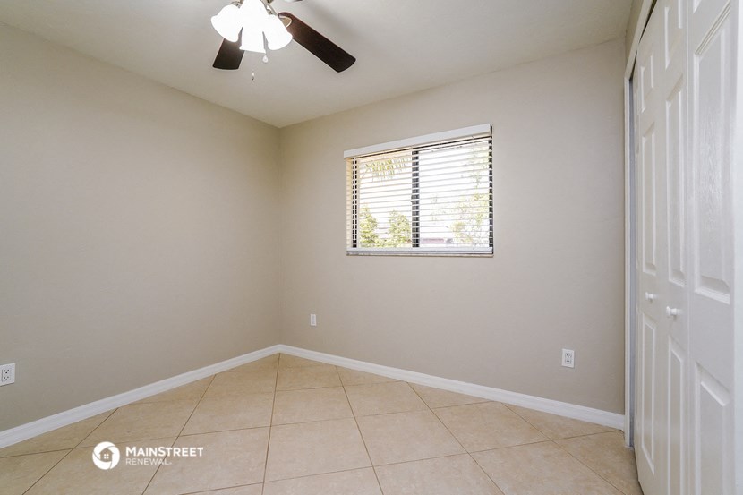 an empty room with a window and a ceiling fan