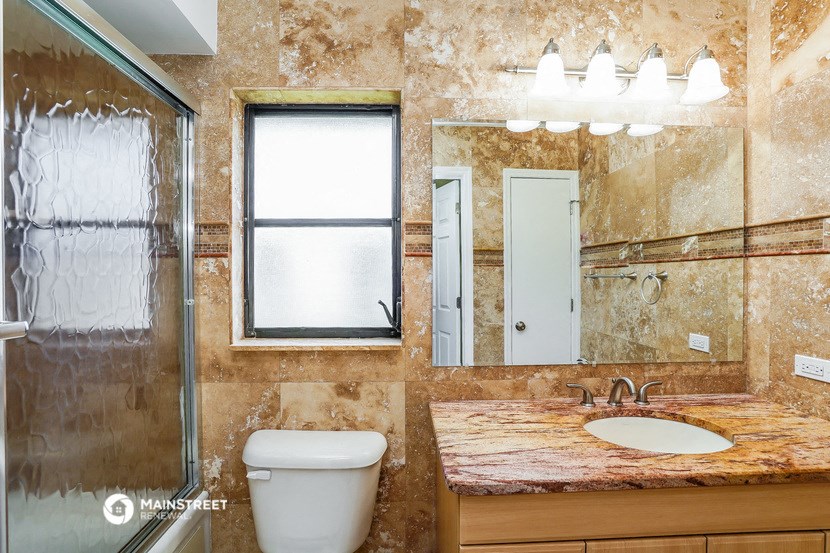 a bathroom with a toilet and a sink and a mirror