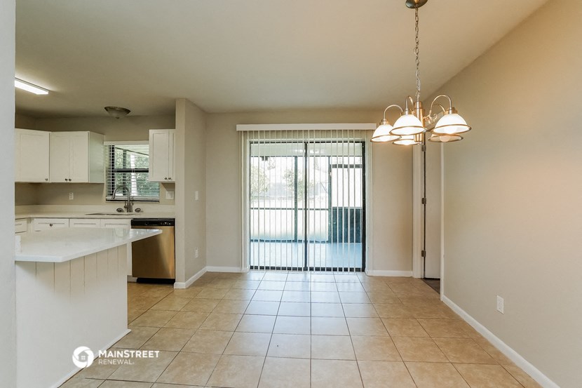 an empty living room and kitchen with a sliding glass door