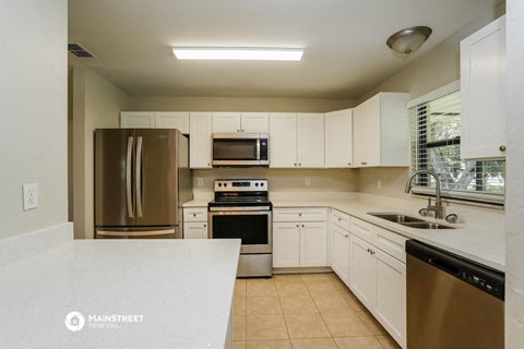 a kitchen with white cabinets and stainless steel appliances