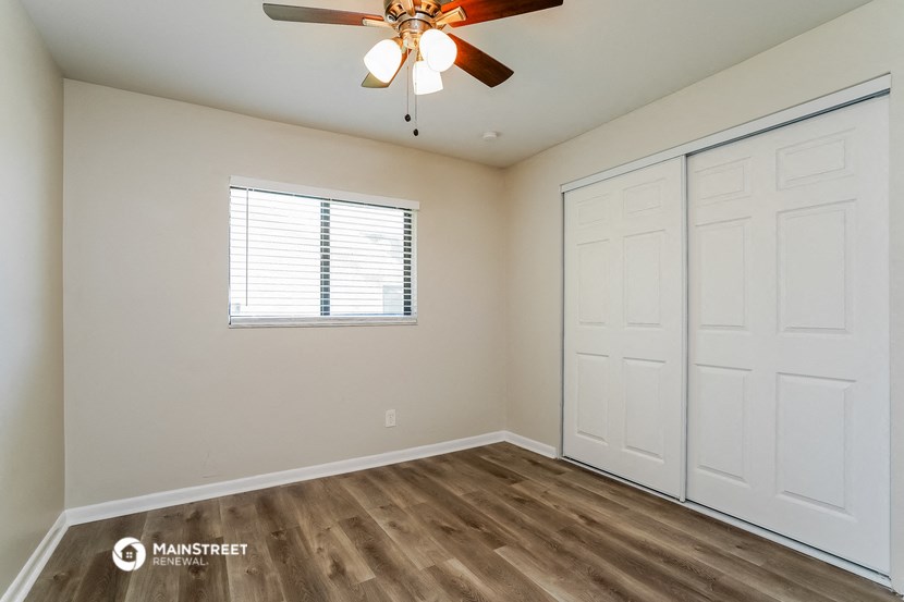 a bedroom with a ceiling fan and a closet