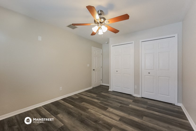 the living room of our studio apartment atrium with ceiling fan and doors