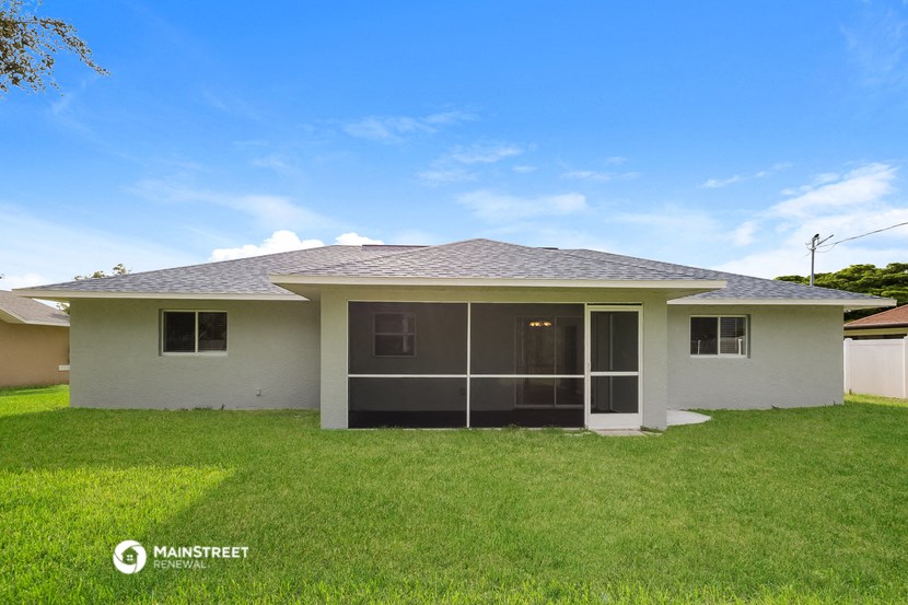 a small house with a lawn and a blue sky