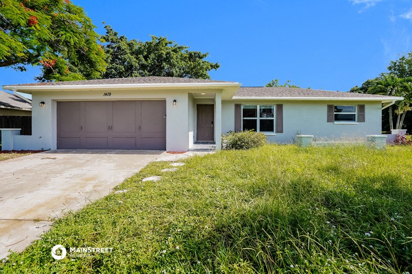 a light blue house with a driveway and a garage door