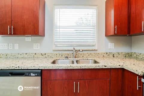 a kitchen with granite counter tops and wooden cabinets