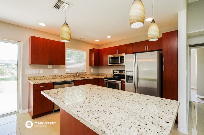 an updated kitchen with granite countertops and stainless steel appliances