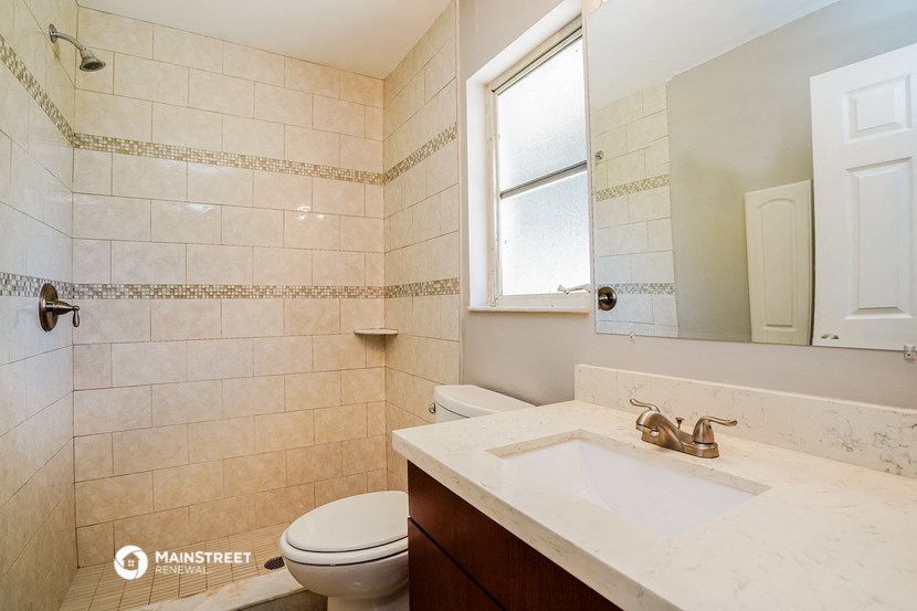 a bathroom with a sink and a toilet and a window
