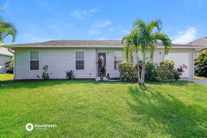 a white house with a palm tree in front of it
