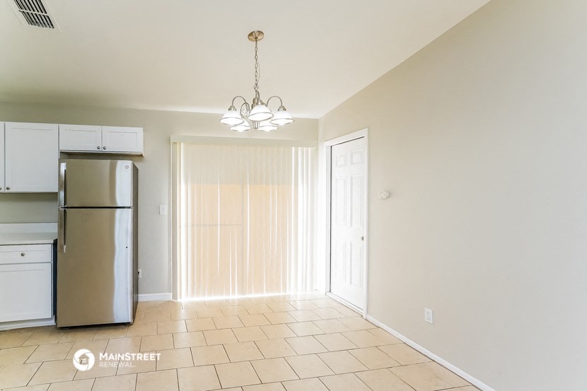 an empty kitchen with a refrigerator and a door to a closet