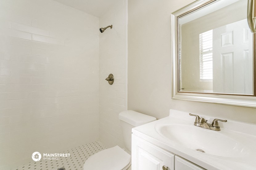 a bathroom with a sink and toilet and a mirror