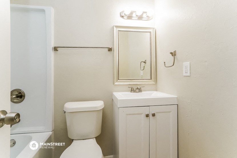 a bathroom with a toilet and a sink and a mirror