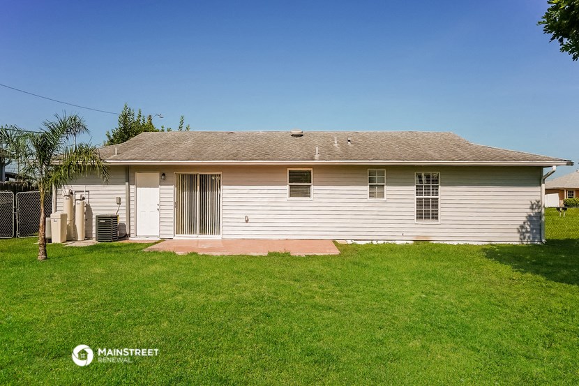 a white house with a grassy yard and a fence