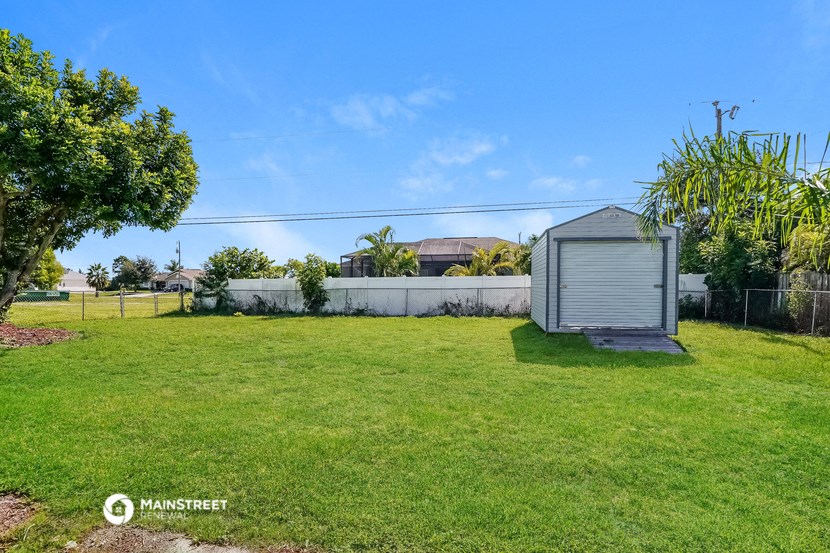 a backyard with a small shed and a grass field