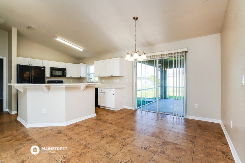 an open kitchen and living room with a sliding glass door to the patio
