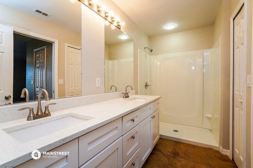 a white bathroom with two sinks and a shower